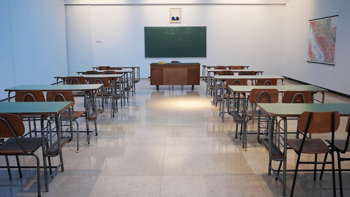 Salle de cours avec tableau vert et pupitres alignés dans un établissement grenoblois